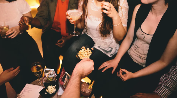 여성 호스피탈리티 종사자들과 함께 음료와 엔터테인먼트를 즐기는 손님들